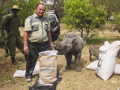 Rodrigues with feed and a rescued rhino calf Rodrigues with feed and a rescued rhino calf